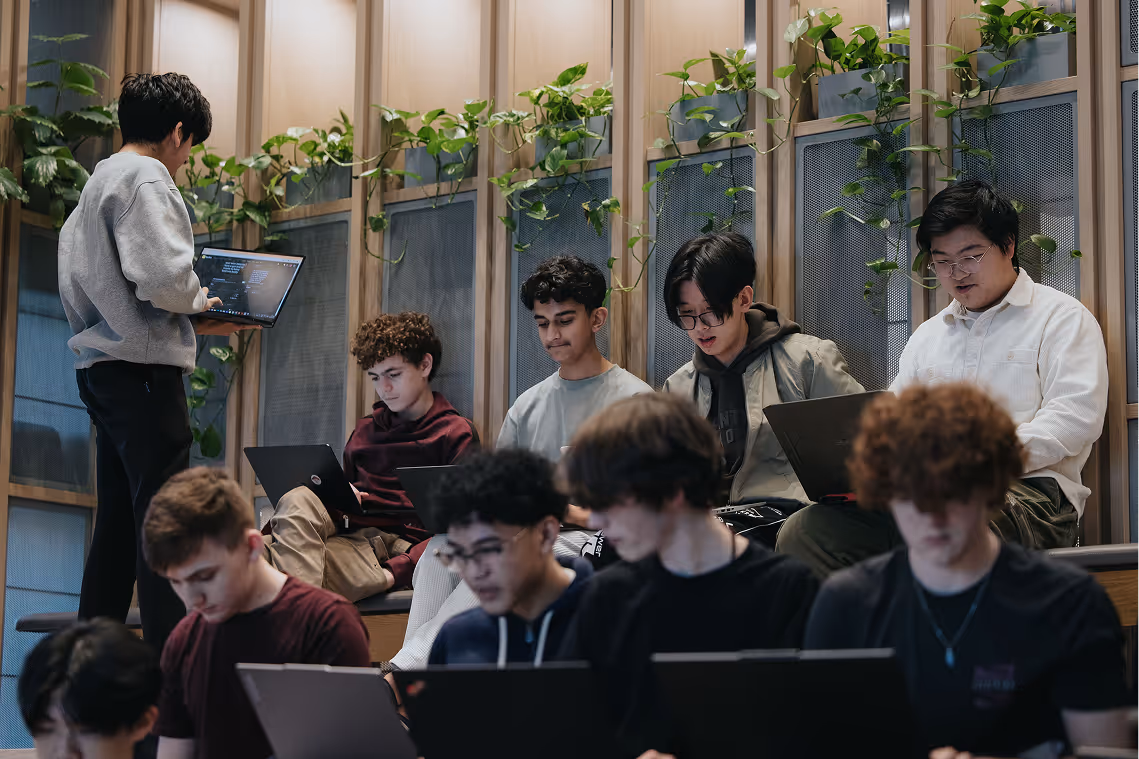 Students on laptops collaborating during a timed challenge